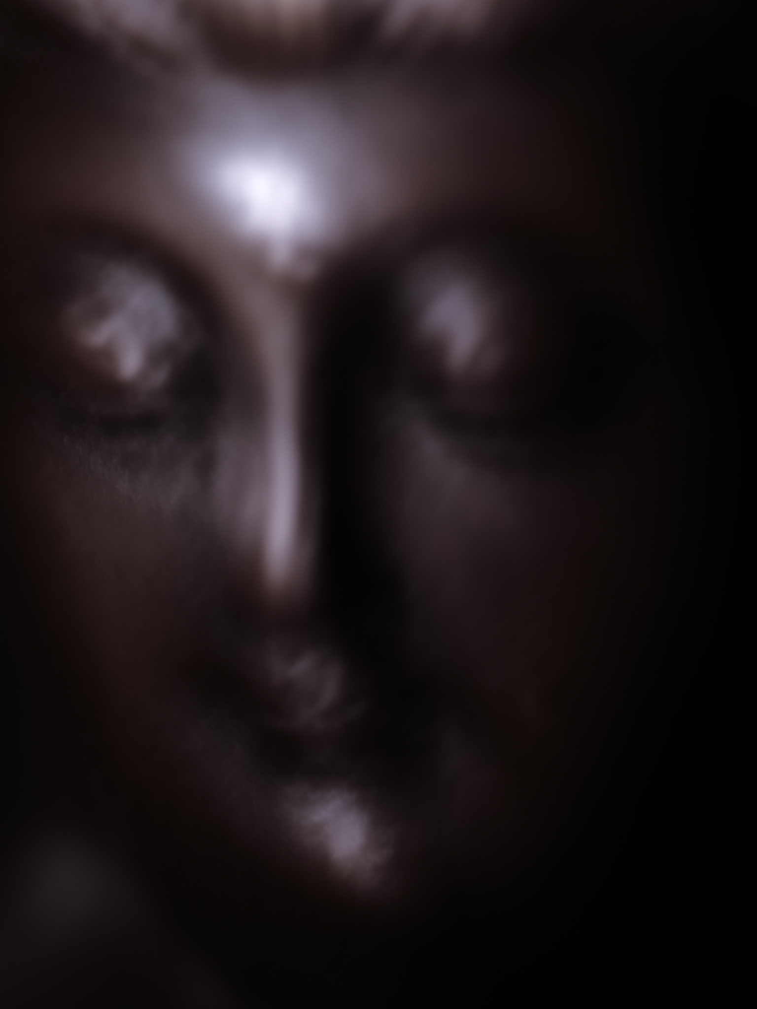 Christian Solorzano — moody low-key close-up of a face half-lost in shadow