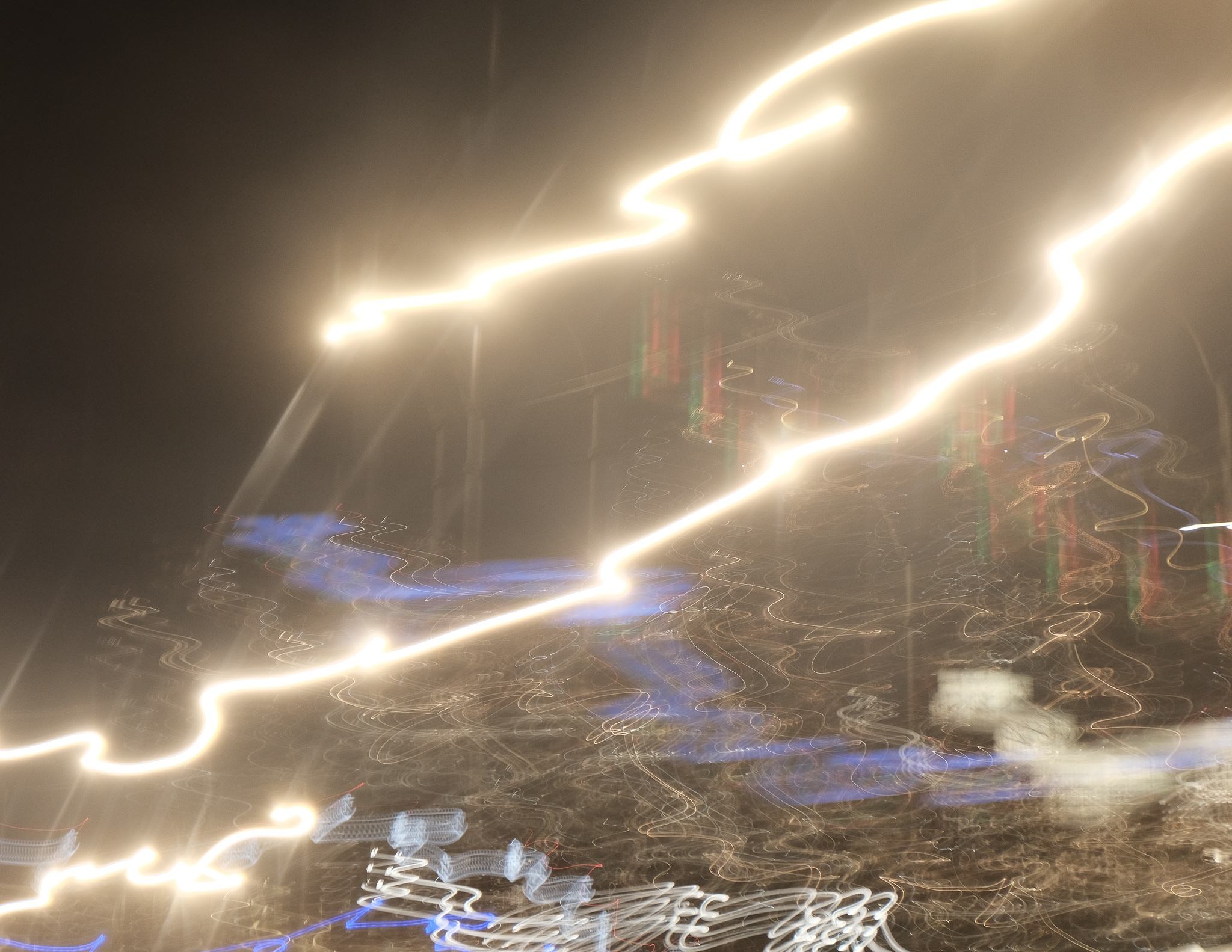 Christian Solorzano — long-exposure abstract of swirling golden and blue light trails at night