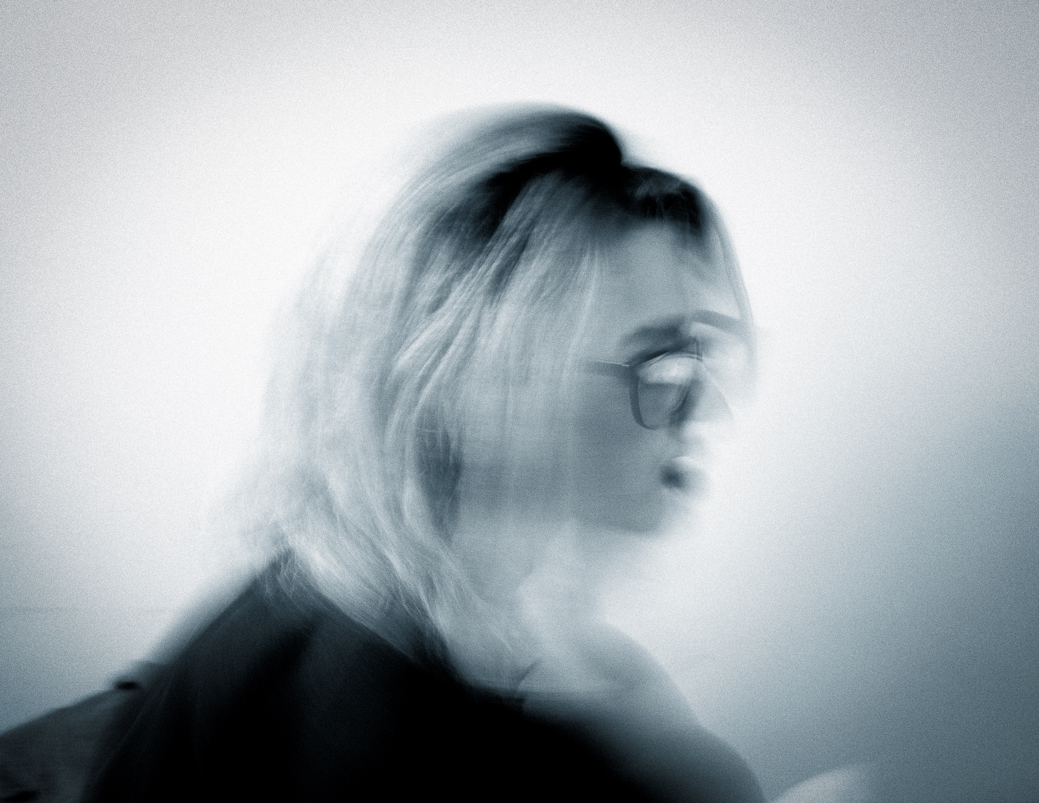 Christian Solorzano — cool-toned motion-blurred portrait of a person with glasses turning their head
