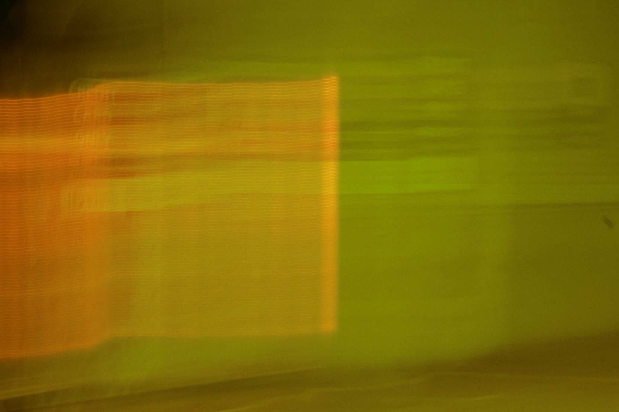 Christian Solorzano — motion-blur abstract of orange and green light from a storefront at night